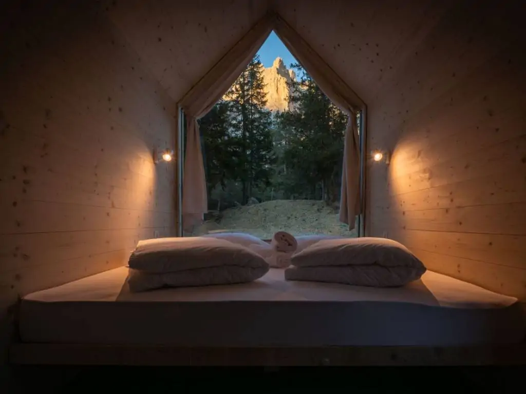 sass-dlacia-forest-cabin-interior-bedroom-pillows-mountain-view